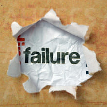 The word 'failure' seen through a hole ripped out of brown paperThe word 'failure' seen through a hole ripped out of brown paper